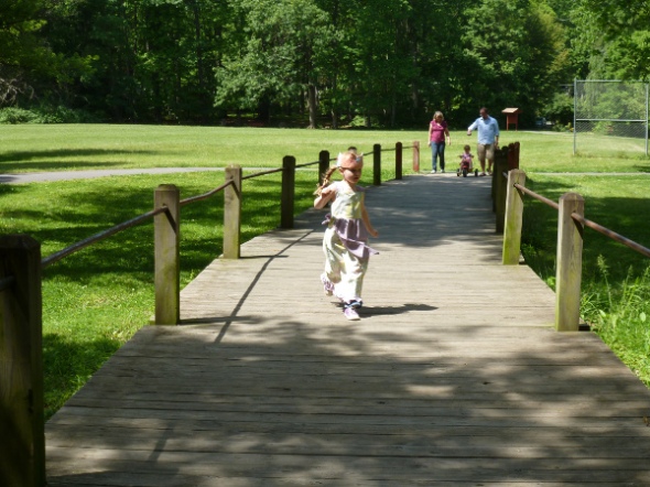 Aria running on wooden bridge, Gma Janie, Daddy and Ani in background